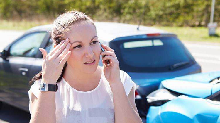 Teen on cell phone with two-car accident in background